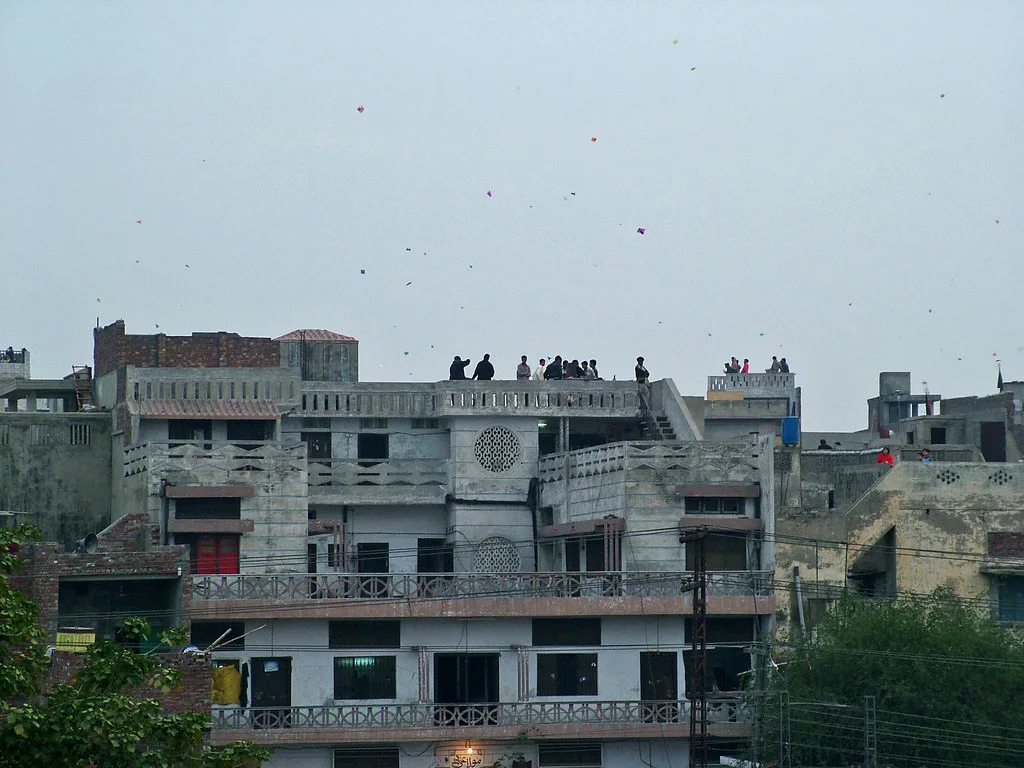 People flying kites from rooftops in Lahore during Basant