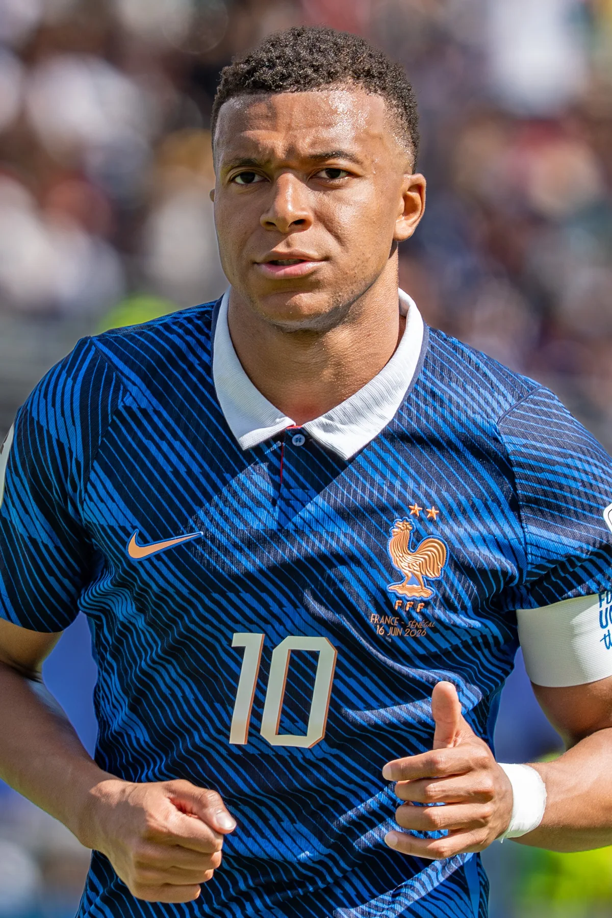 Kylian Mbappe jogging in France blue number 10 shirt with captain armband during a match