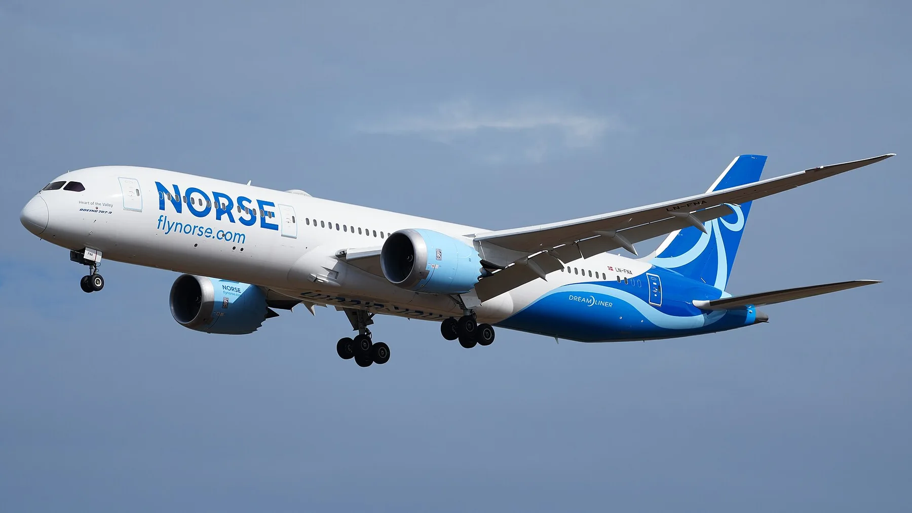 Norse Atlantic Boeing 787-9 Dreamliner in blue and white livery with landing gear down against a grey sky