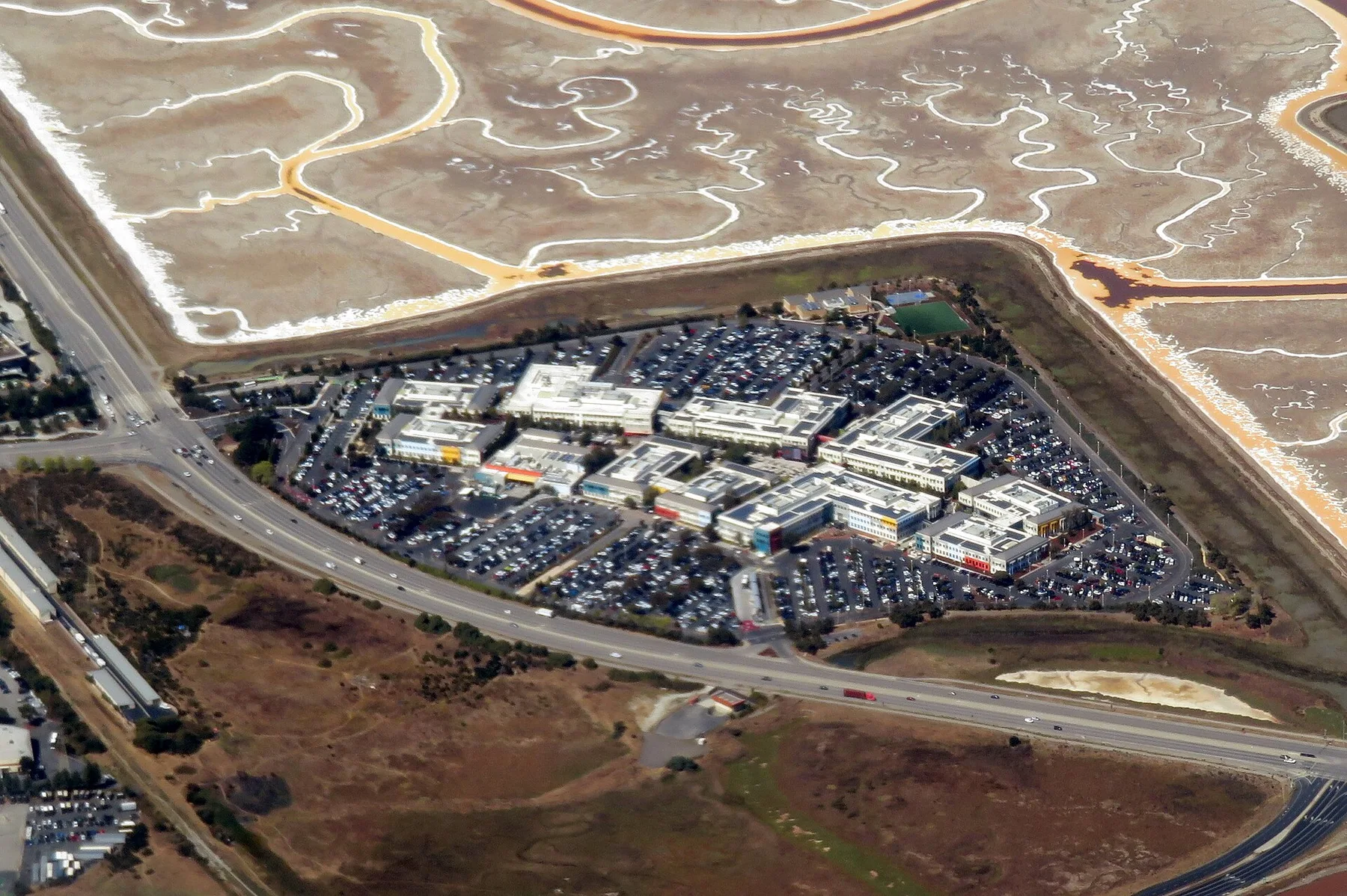 Aerial view of the Meta headquarters campus in Menlo Park beside the salt marshes of San Francisco Bay