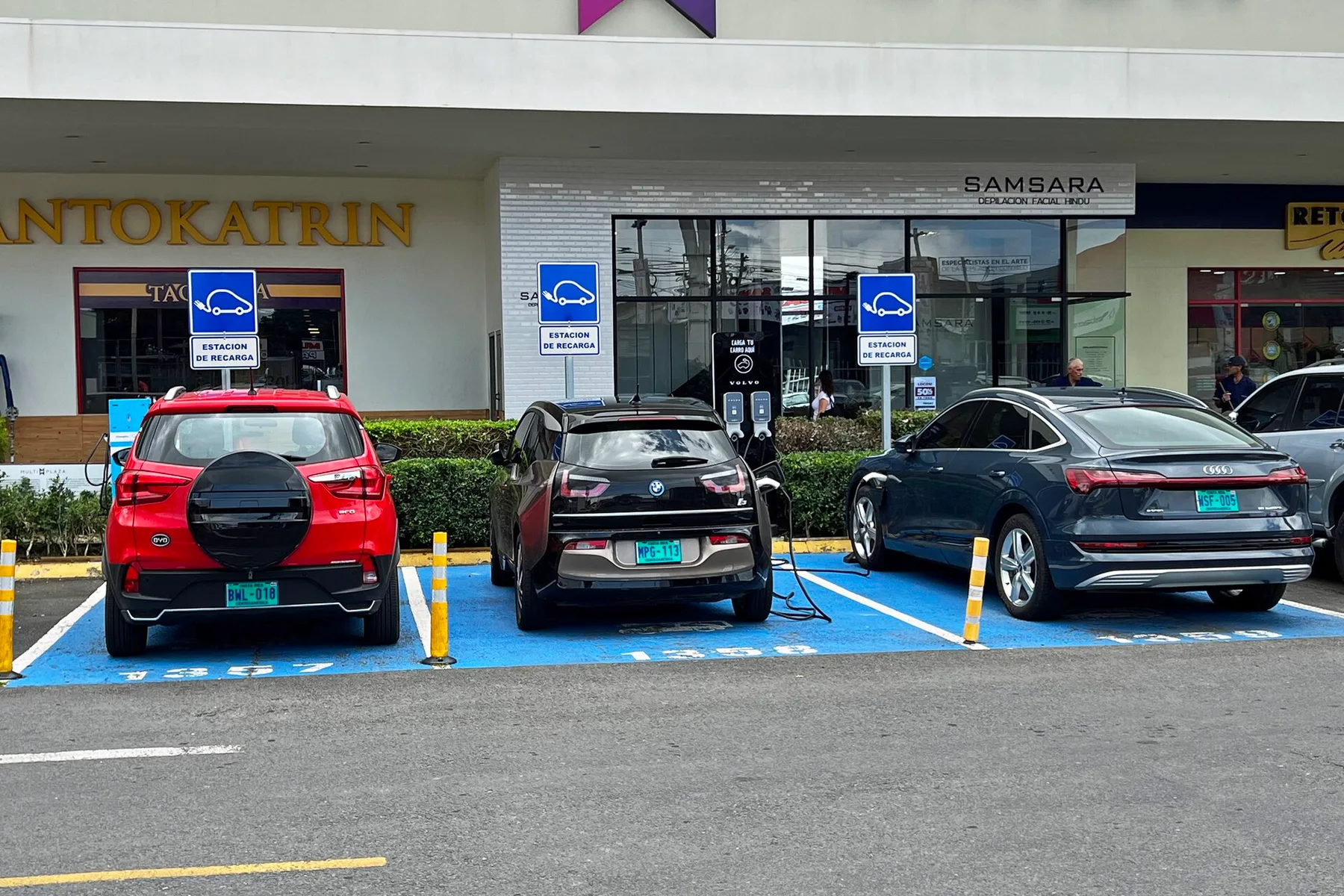 Red BYD SUV parked at an electric car charging bay beside other EVs plugged in