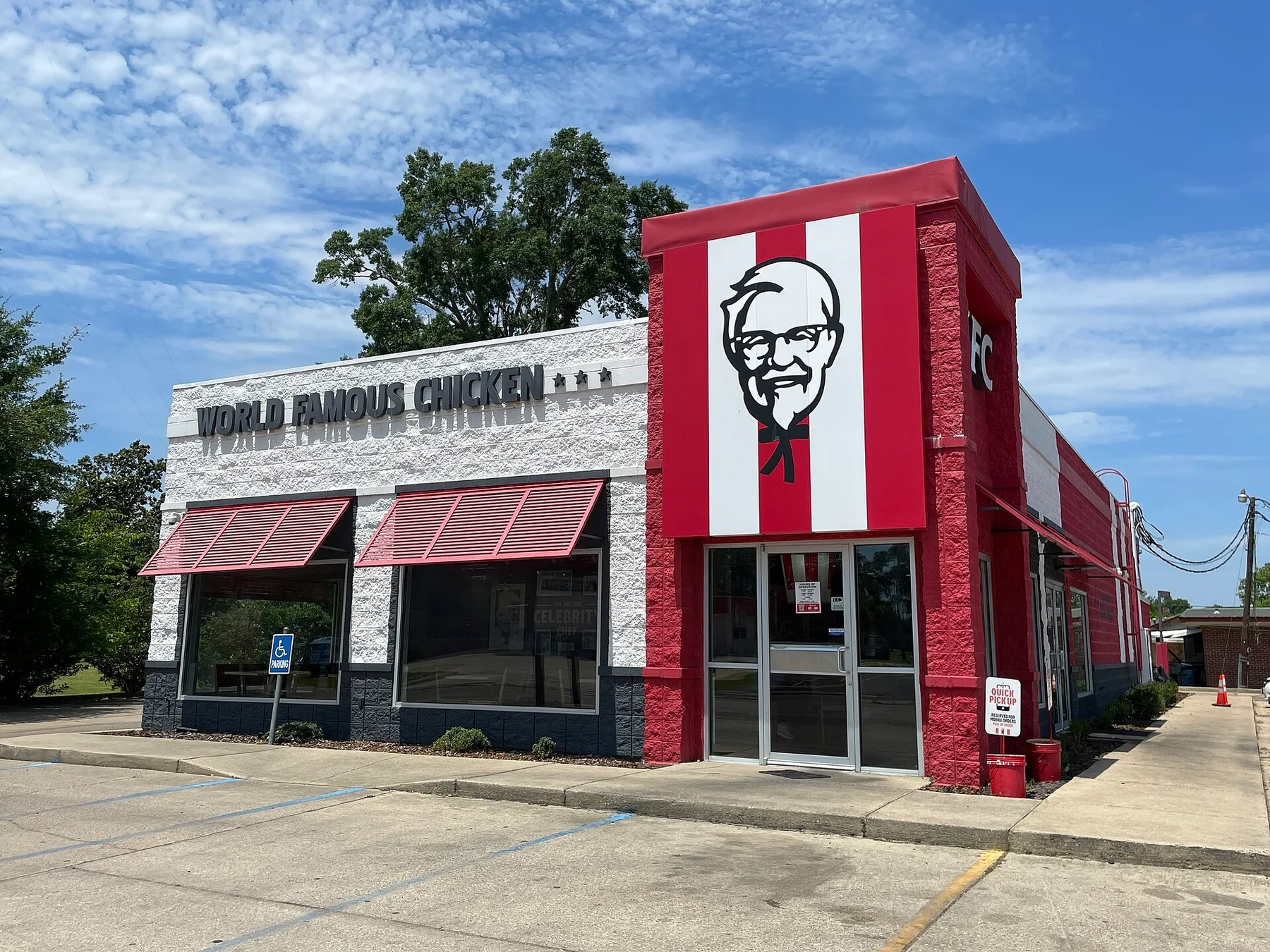 KFC restaurant with a red and white striped front, Colonel Sanders logo and World Famous Chicken sign