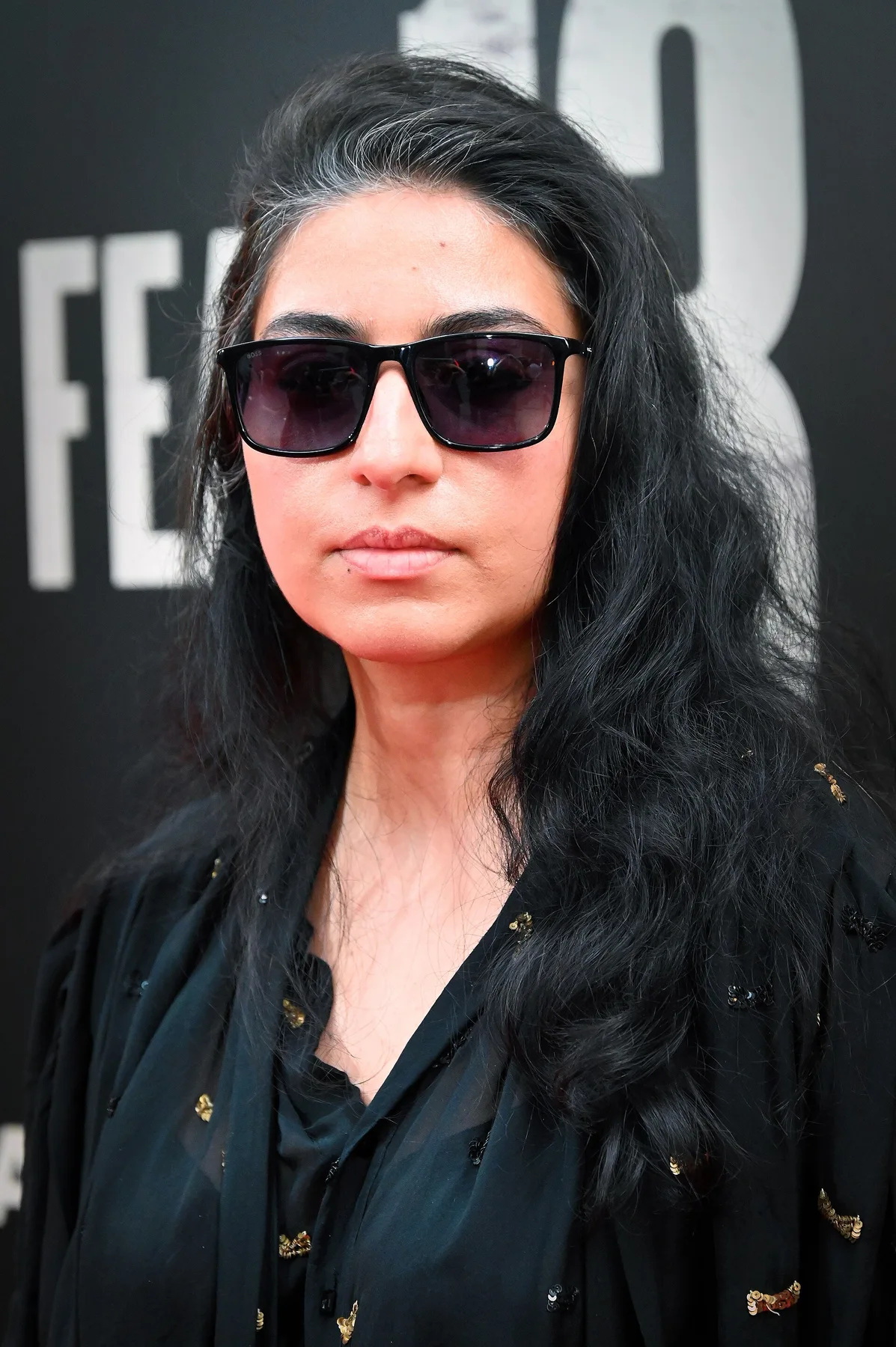 Arooj Aftab in dark sunglasses and a black sequinned top at a red carpet event