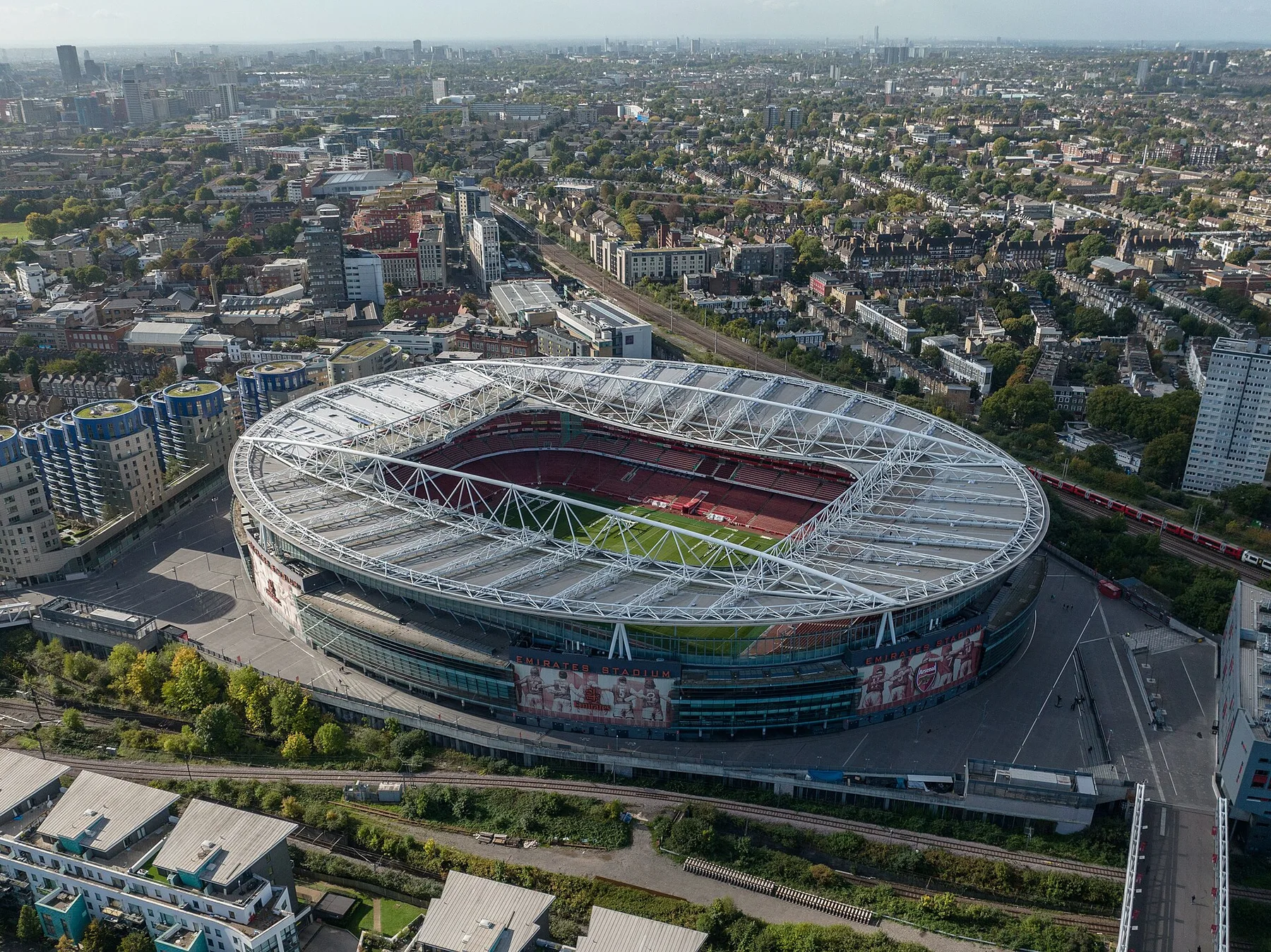 Aerial view of the Emirates Stadium bowl and its white roof among north London streets