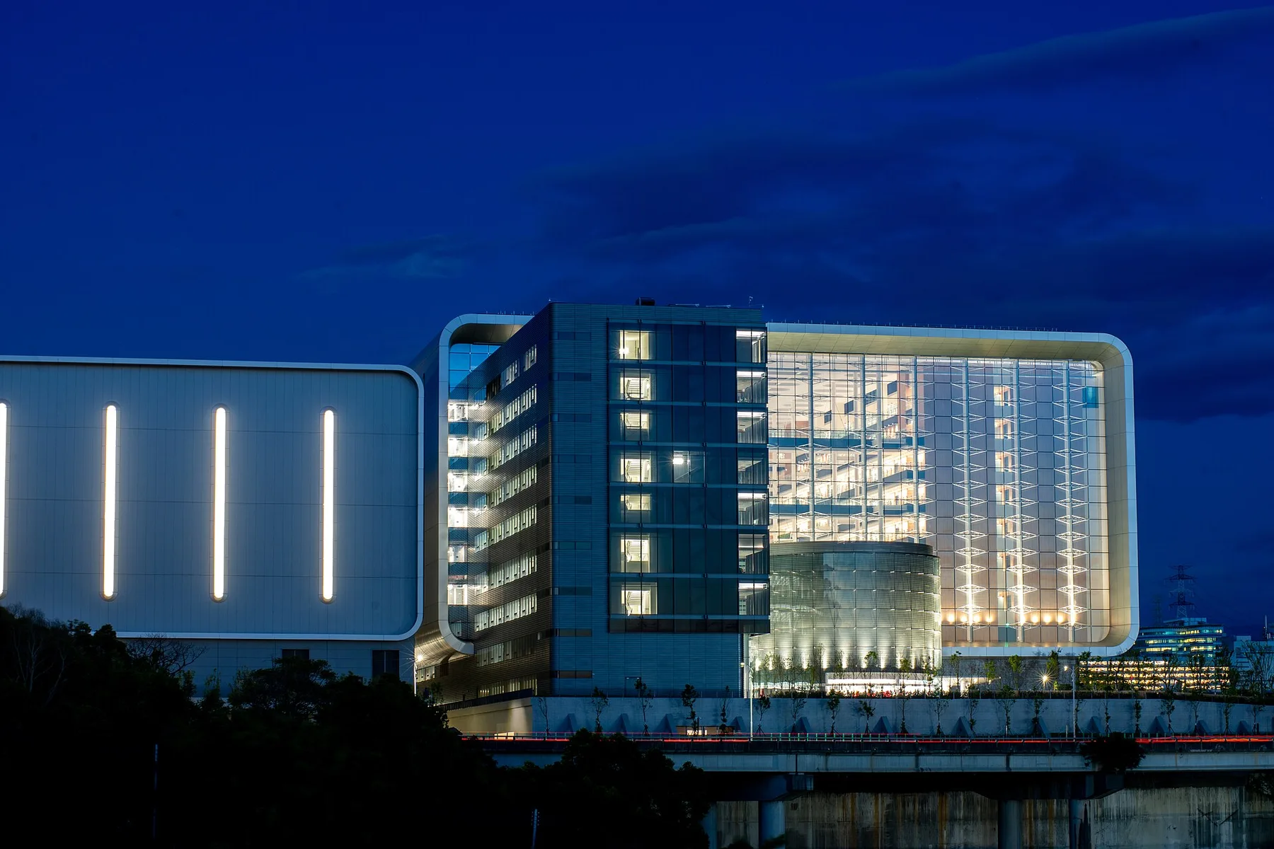 TSMC office and research building lit up at dusk beside an elevated road in Taiwan