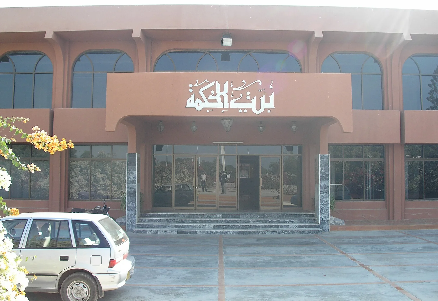 Entrance of the Bait-ul-Hikmah library building at Hamdard University, Karachi, with a car parked in front