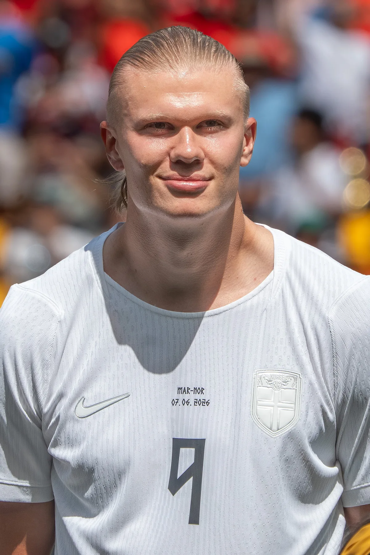 Erling Haaland in a white Norway number 9 shirt smiling before a match