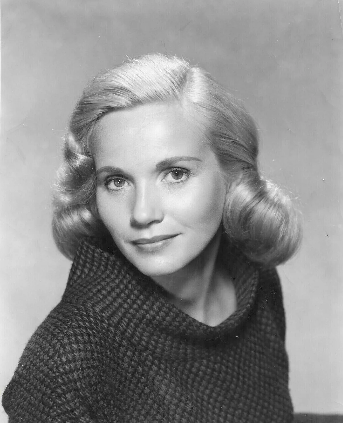 Black-and-white studio portrait of a young Eva Marie Saint in a knitted roll-neck sweater, about 1951