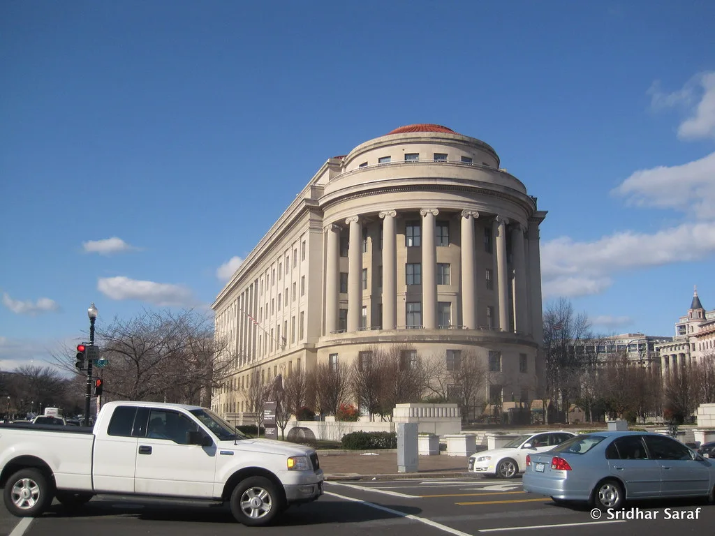 The Federal Trade Commission building in Washington, with its rounded columned corner, under a blue sky