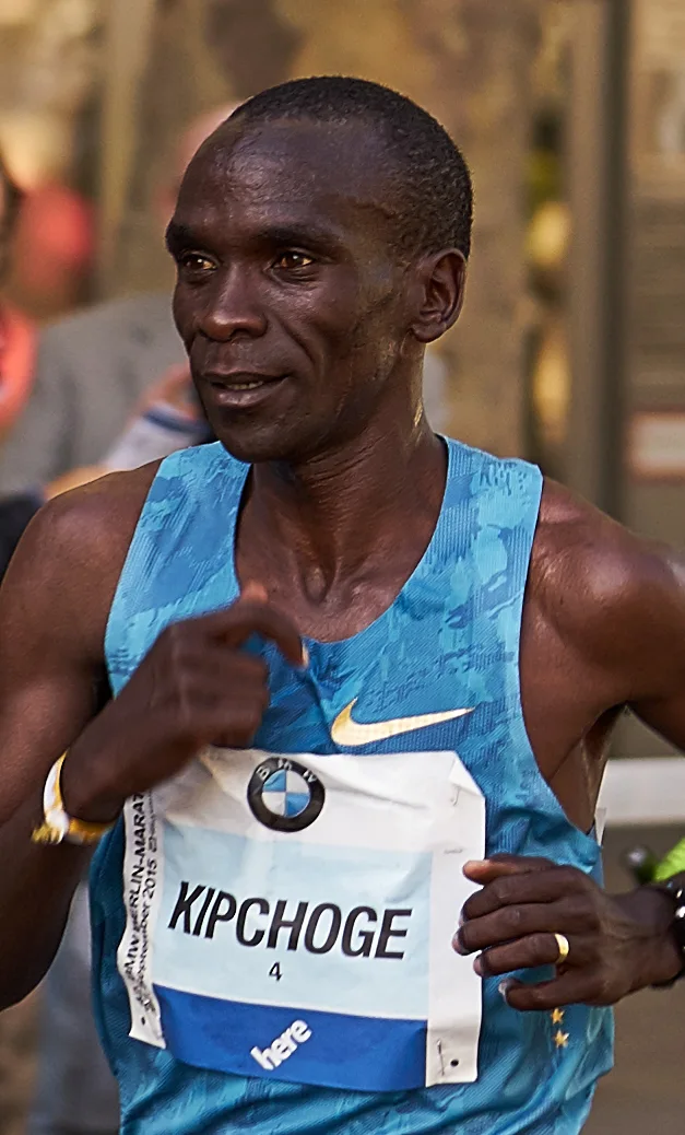 Eliud Kipchoge running in a blue vest with his race bib at the Berlin Marathon