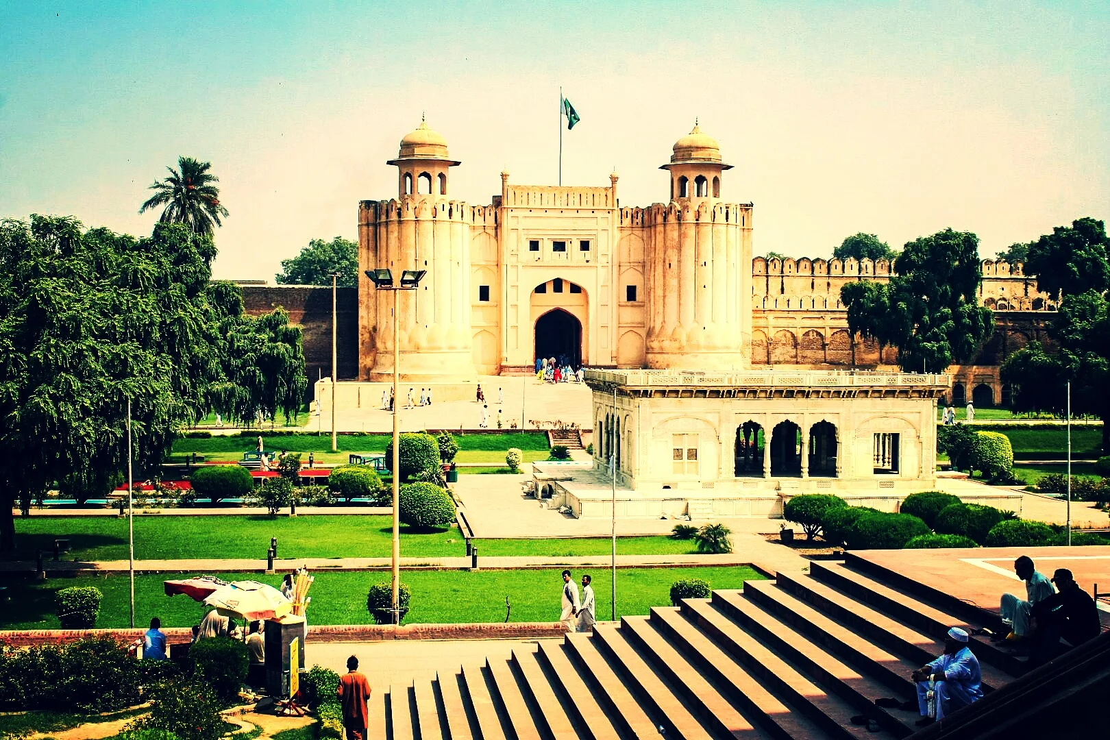 Lahore Fort's Alamgiri Gate with twin domed towers, green lawns and a white pavilion in front