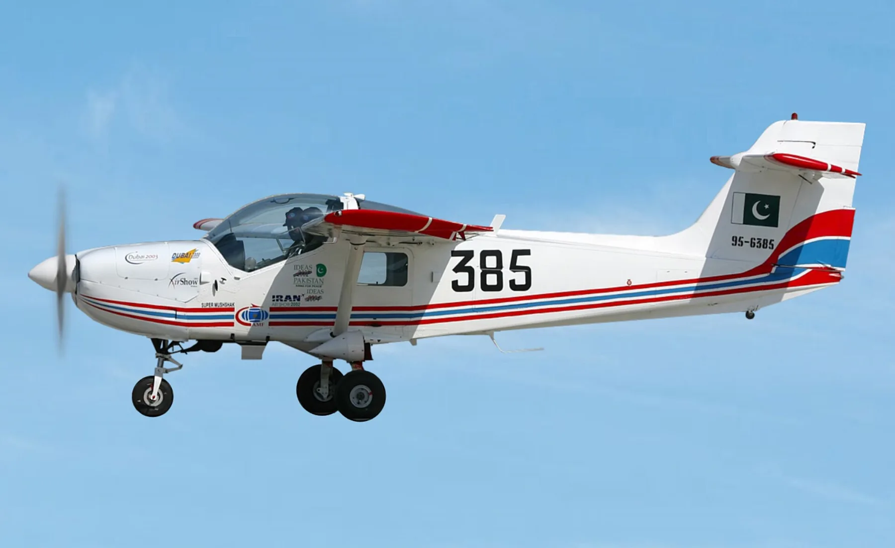 White Super Mushshak trainer aircraft, number 385, with Pakistan flag on its tail, flying in clear sky