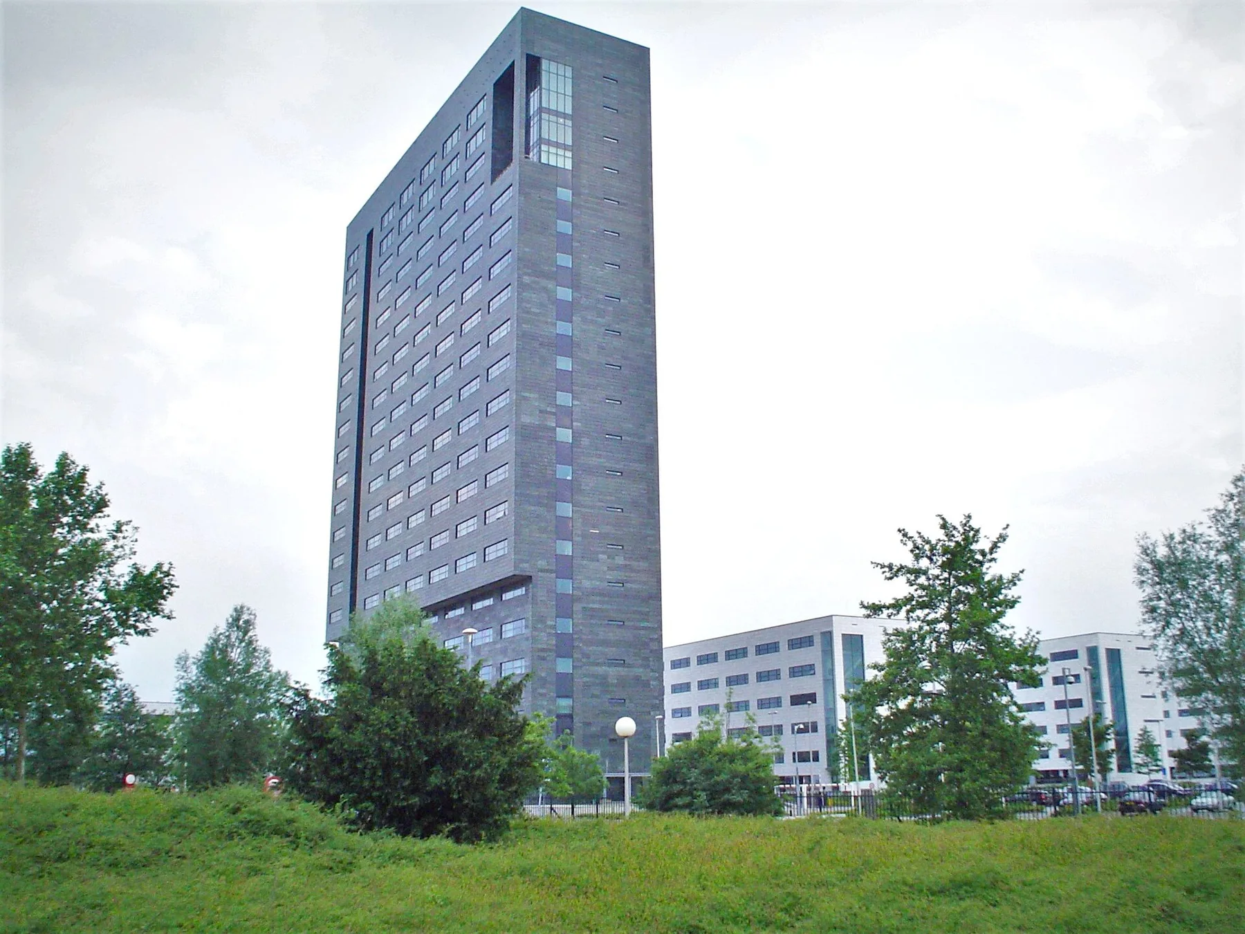 ASML headquarters tower in Veldhoven, Netherlands, with low office buildings and trees in front