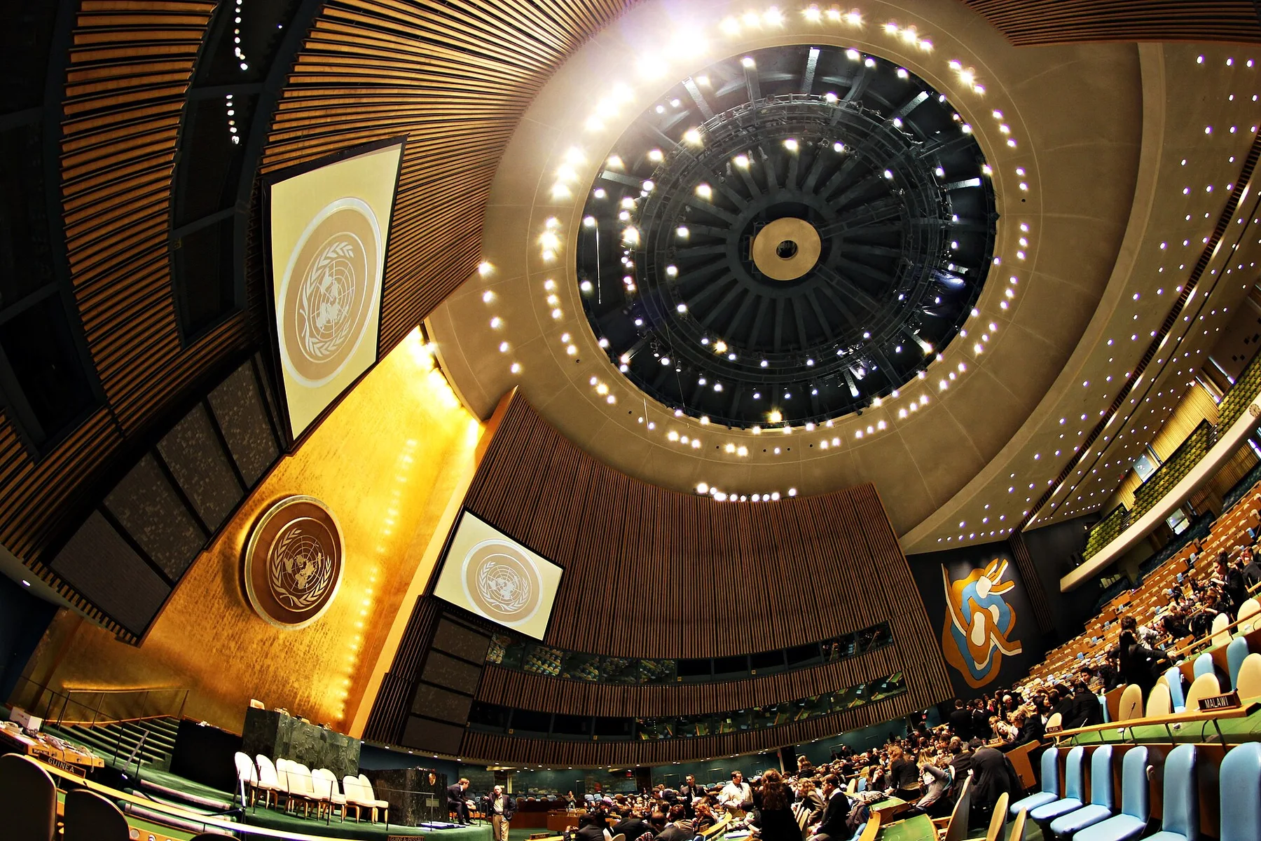 UN General Assembly hall in New York under its domed ceiling, with the UN emblem and delegates seated