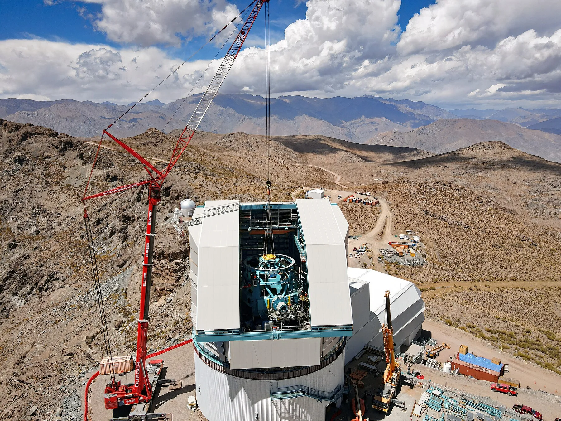 Crane lowers equipment into the open dome of the Vera C. Rubin Observatory on a mountaintop in Chile