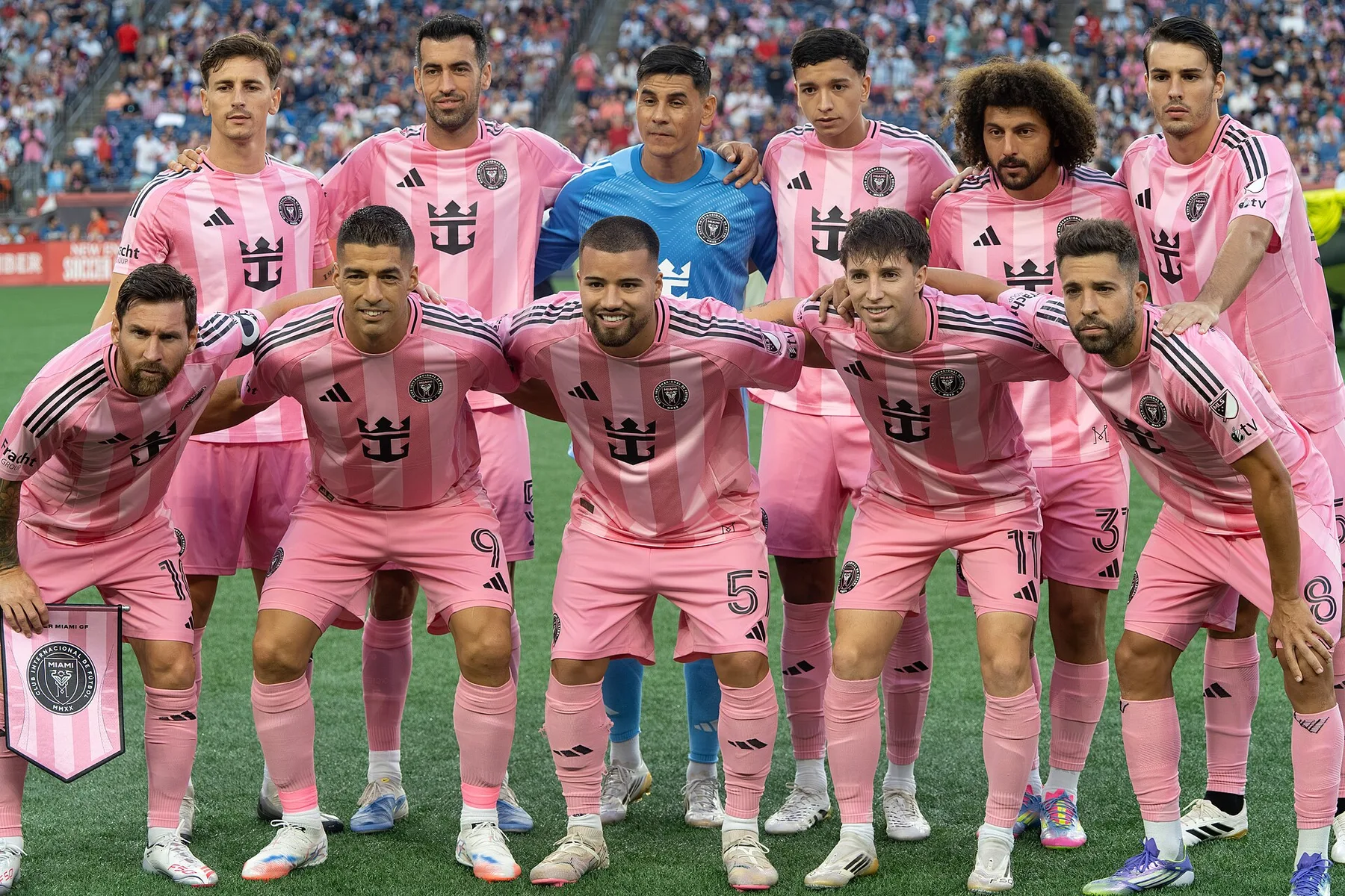 Inter Miami players in pink kits, including Lionel Messi and Luis Suarez, line up for a team photo