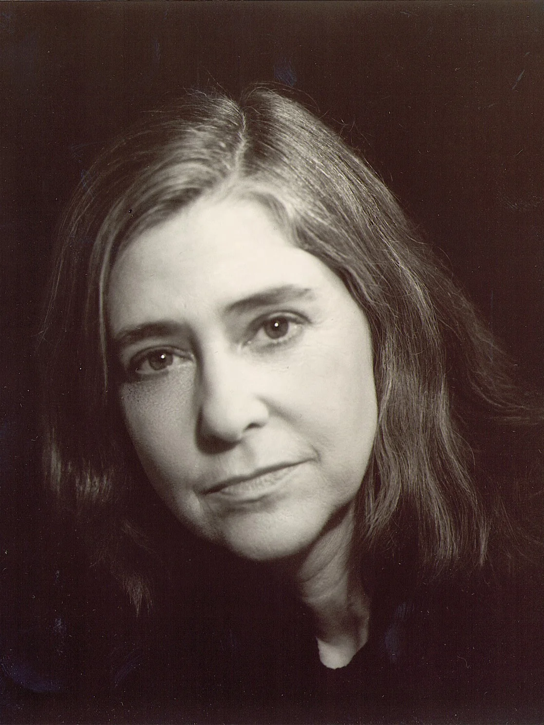 Black and white studio portrait of Margaret Hamilton with shoulder-length hair against a dark background