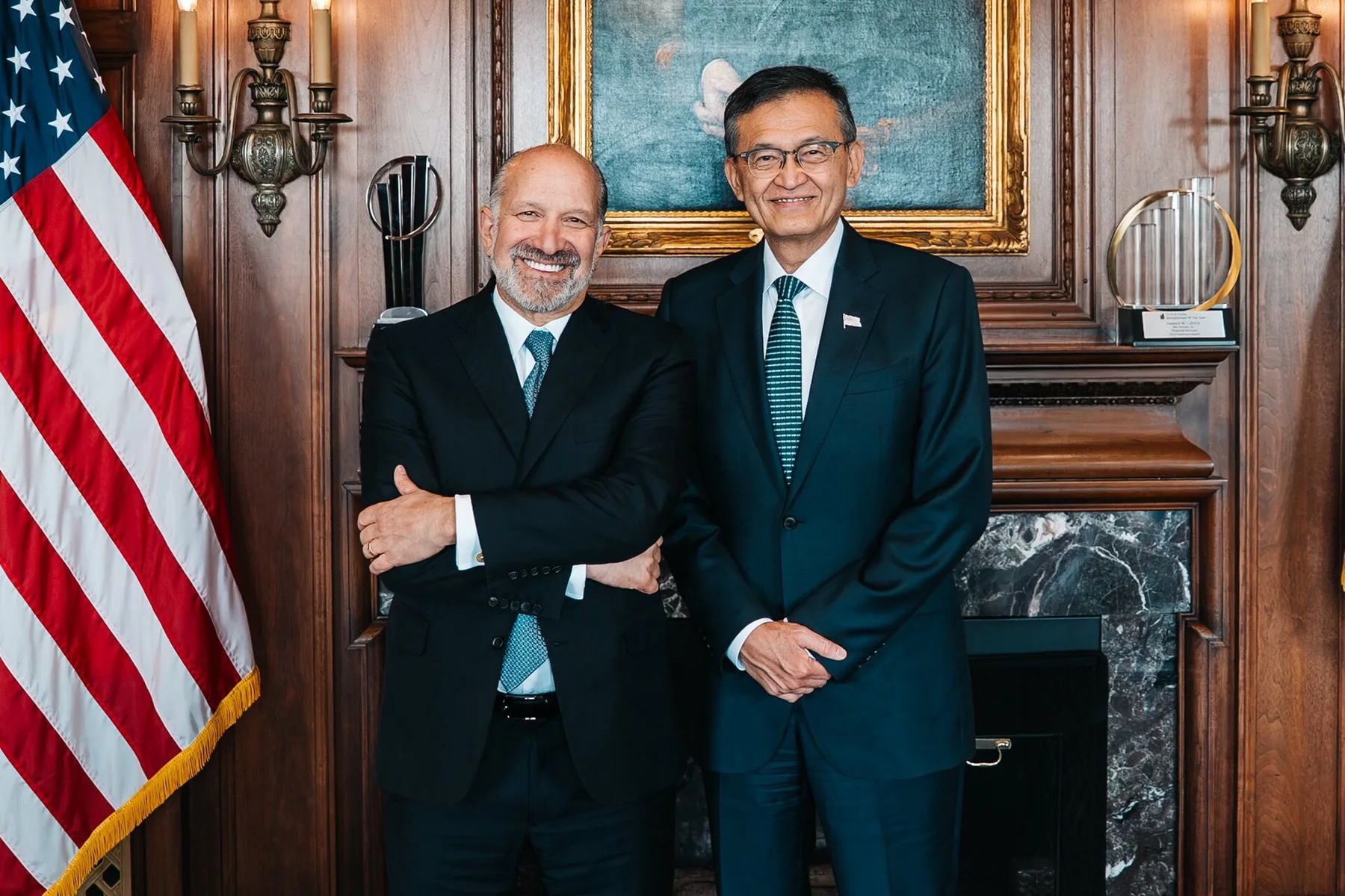 Intel chief executive Lip-Bu Tan, right, smiling beside another man in a wood-panelled office with a US flag