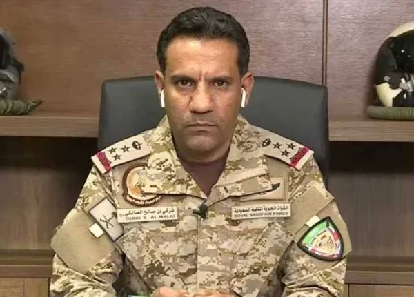 Coalition spokesman Turki Al-Maliki in Royal Saudi Air Force camouflage uniform, seated at a desk
