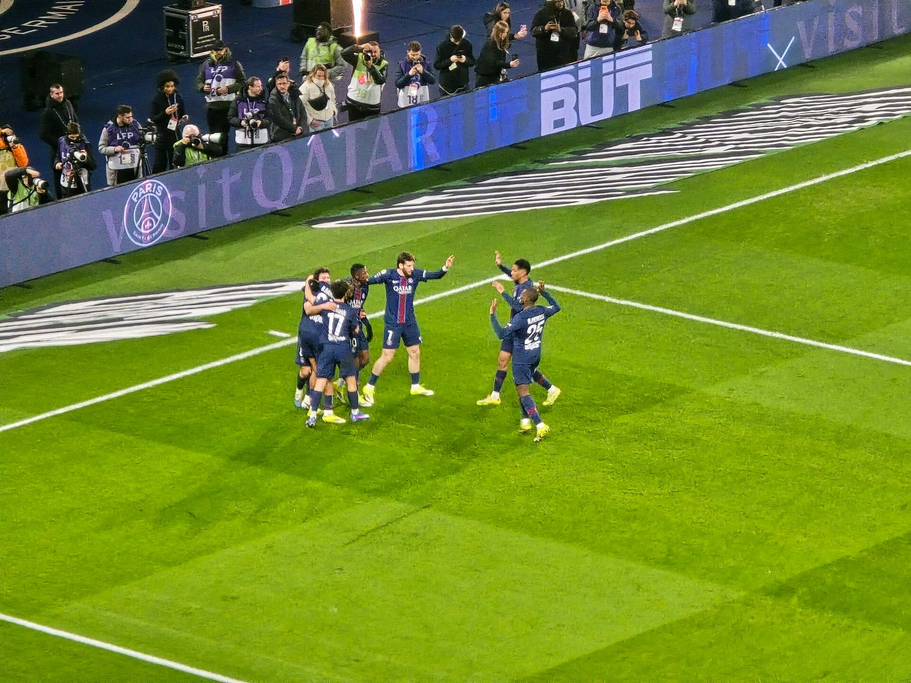 PSG players celebrate a goal together on the pitch, Kvaratskhelia in the number 7 shirt among them