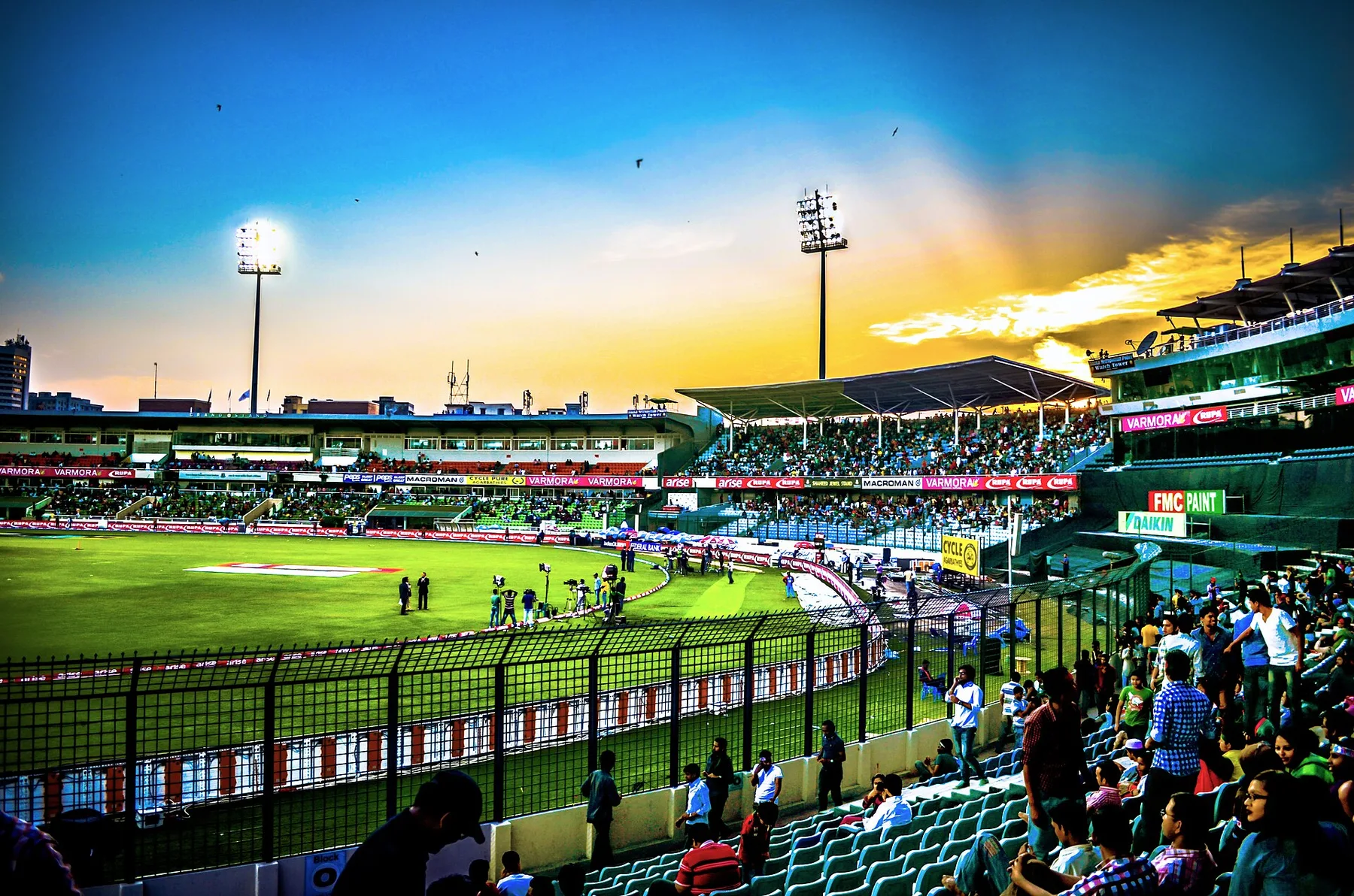 Floodlit Shere Bangla National Stadium in Mirpur at sunset with fans in the stands
