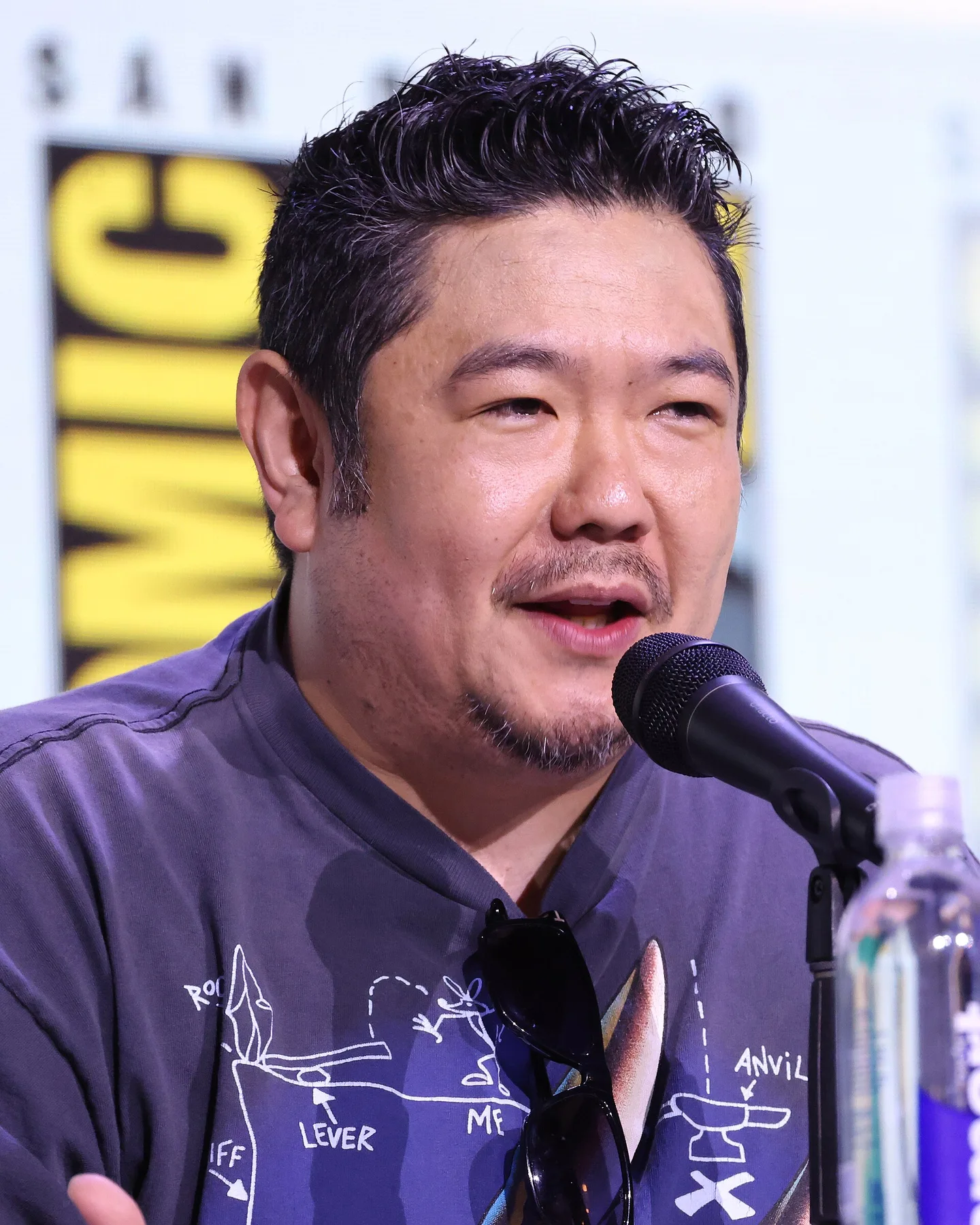 Eric Bauza speaking into a microphone on a panel at San Diego Comic-Con