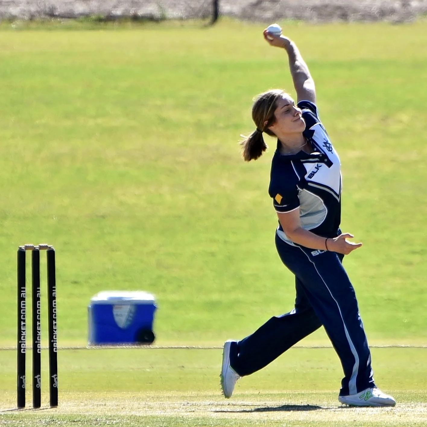 Sophie Molineux in Victoria navy kit delivering the ball on a sunny cricket ground