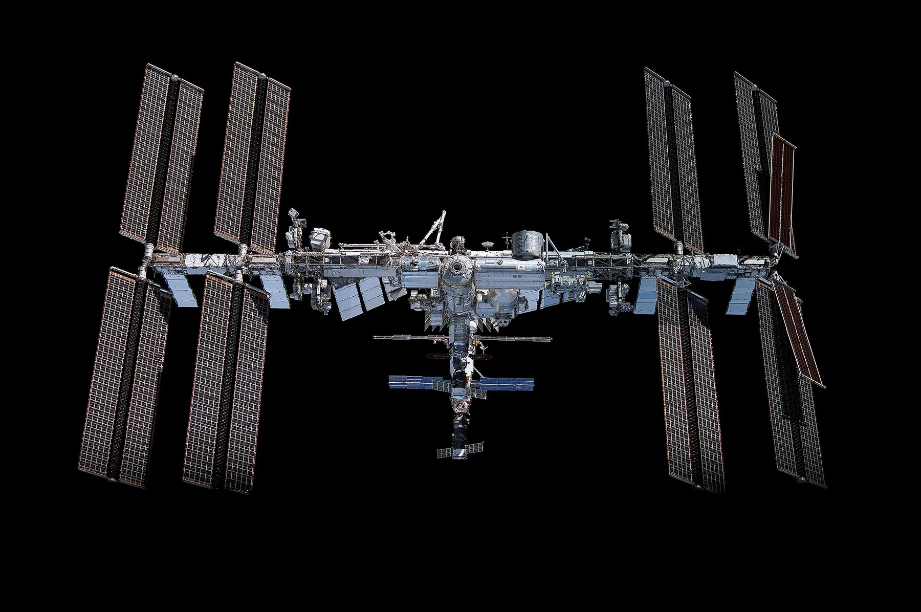 The International Space Station with its solar arrays spread out against the black of space