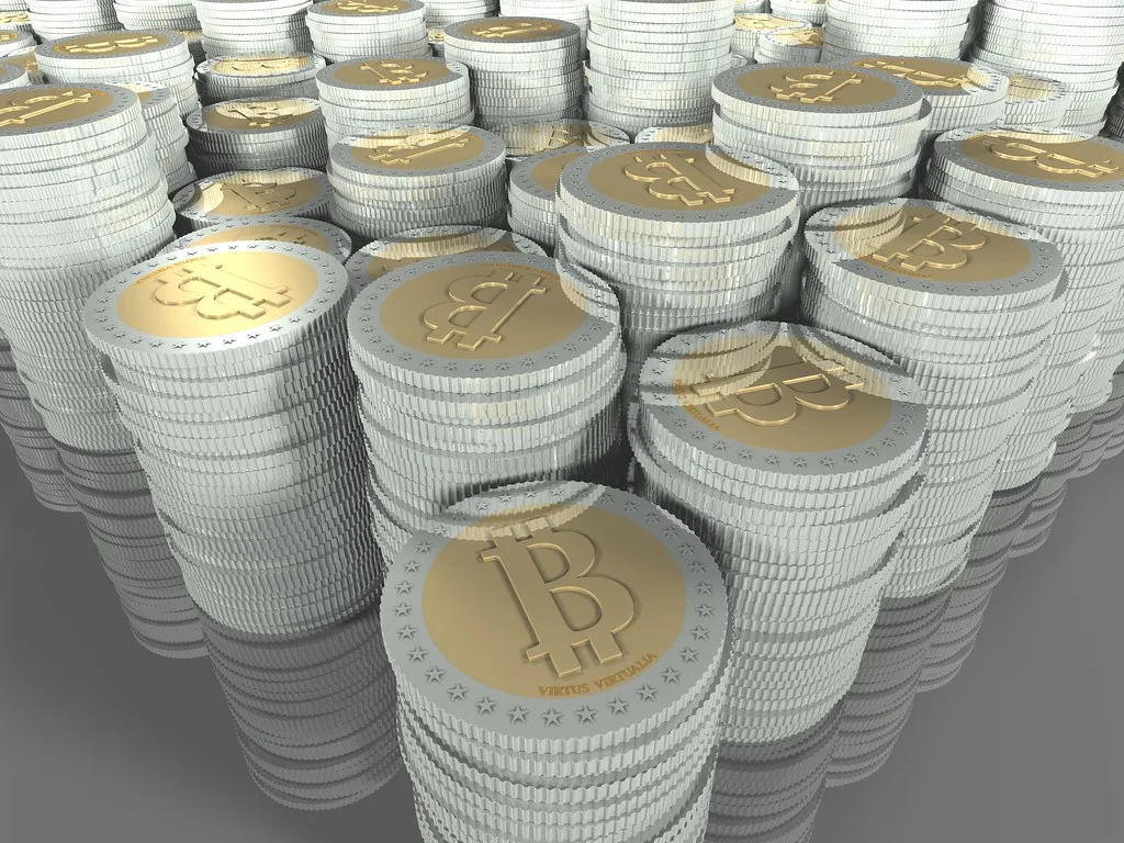 Stacks of gold and silver coins stamped with the bitcoin symbol