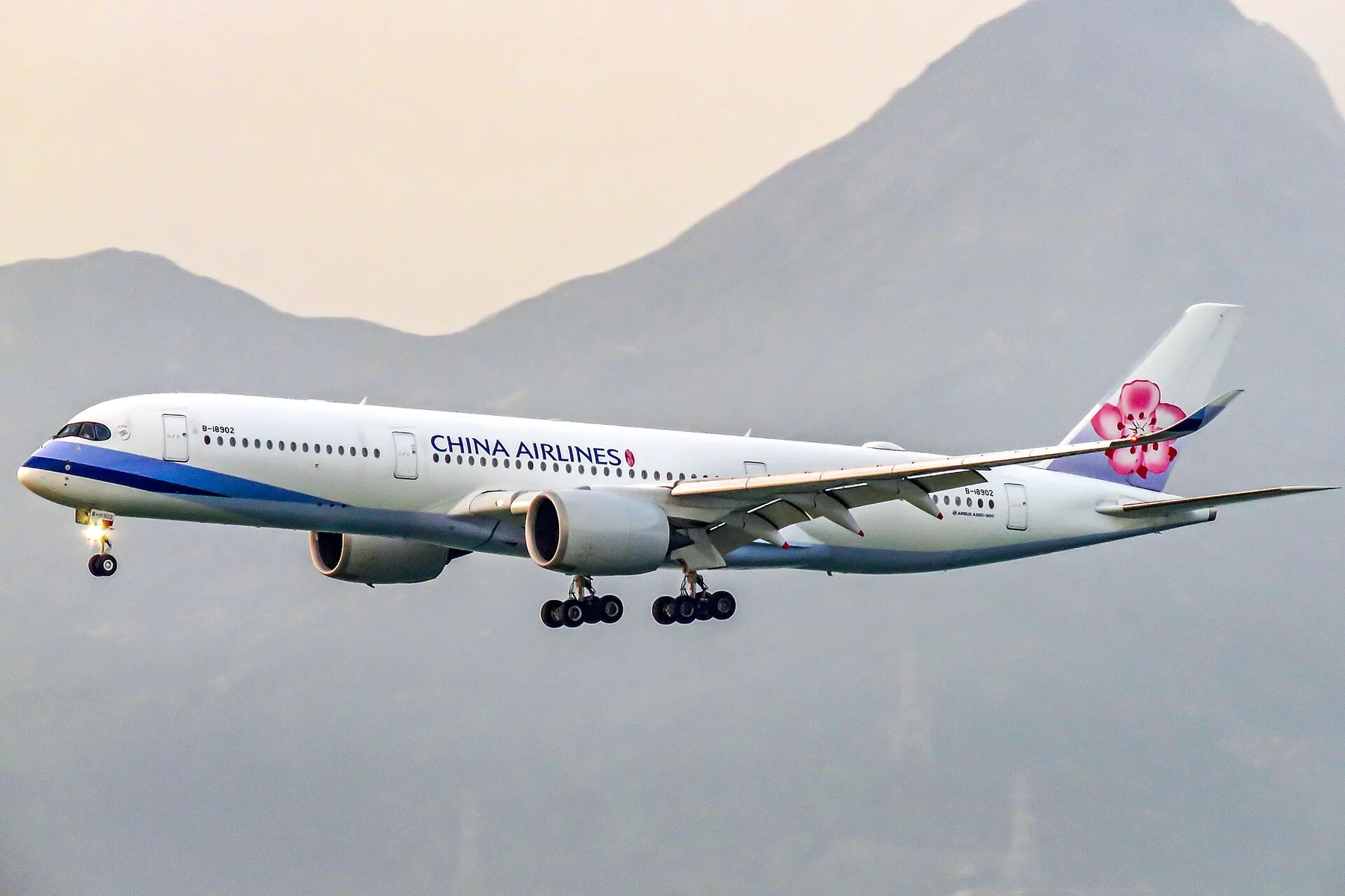 China Airlines Airbus A350 with plum blossom tail landing in front of a misty mountain