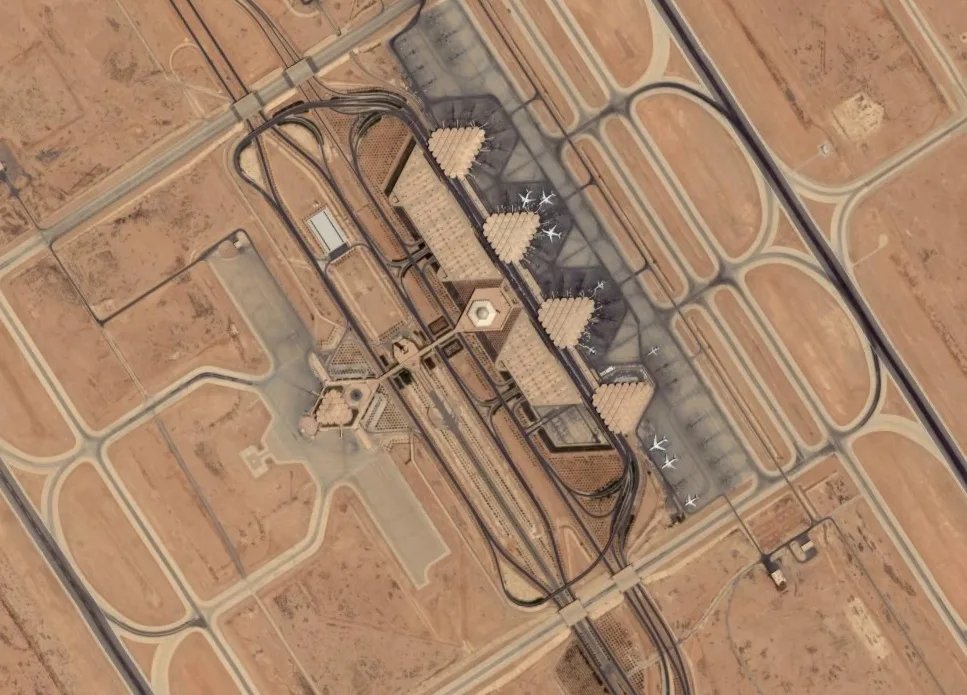 Satellite view of King Khalid International Airport in Riyadh, its terminals, taxiways and parked aircraft in the desert