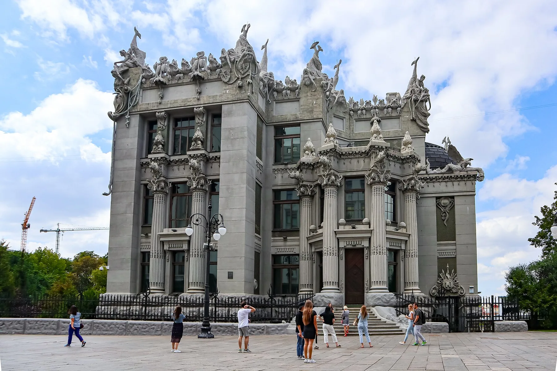 The ornate grey House with Chimaeras in central Kyiv, with pedestrians on the square in front