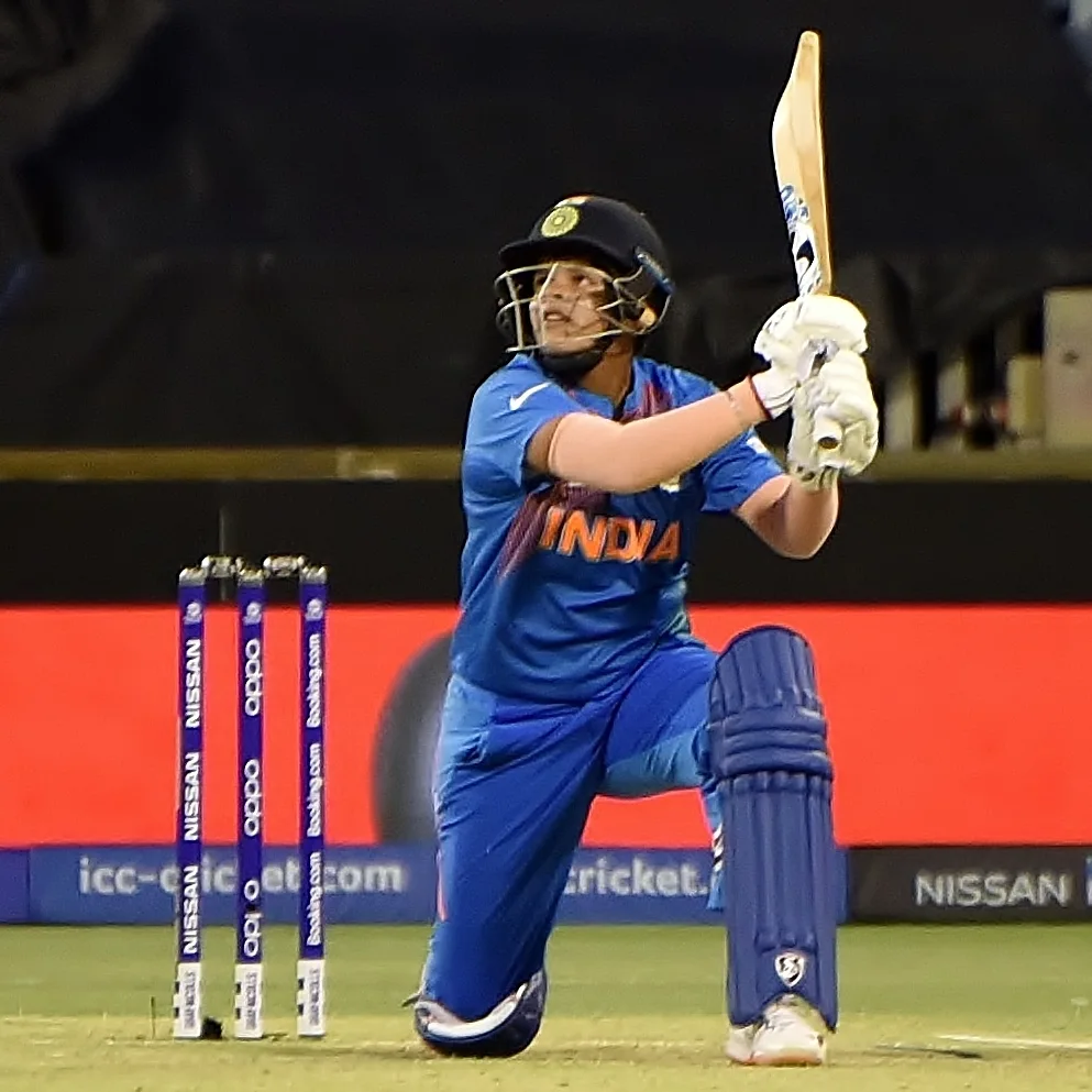 Shafali Verma in India blue kit lofts the ball, down on one knee beside the stumps
