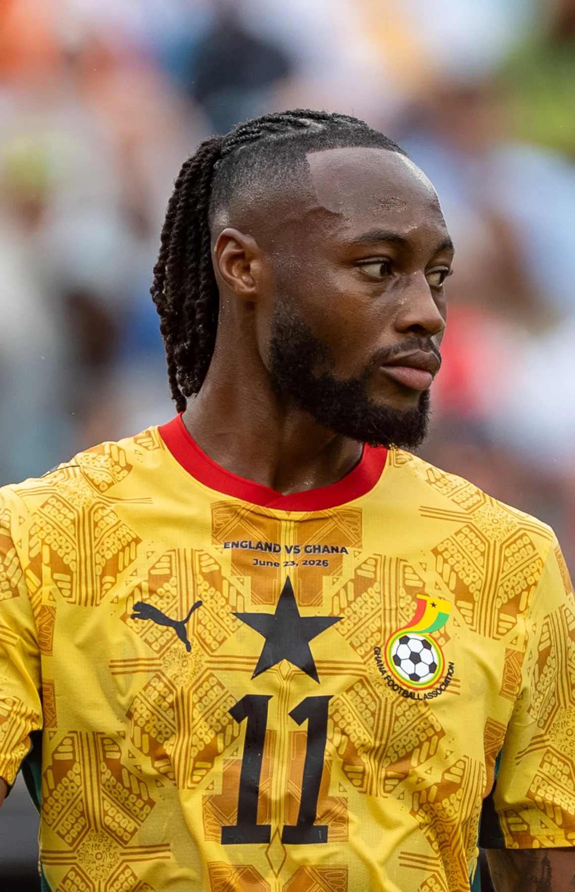 Antoine Semenyo in Ghana yellow number 11 shirt during a match, looking to his left