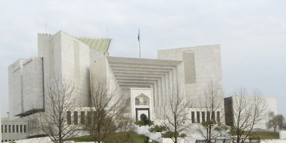 White marble Supreme Court of Pakistan building in Islamabad with bare trees in front