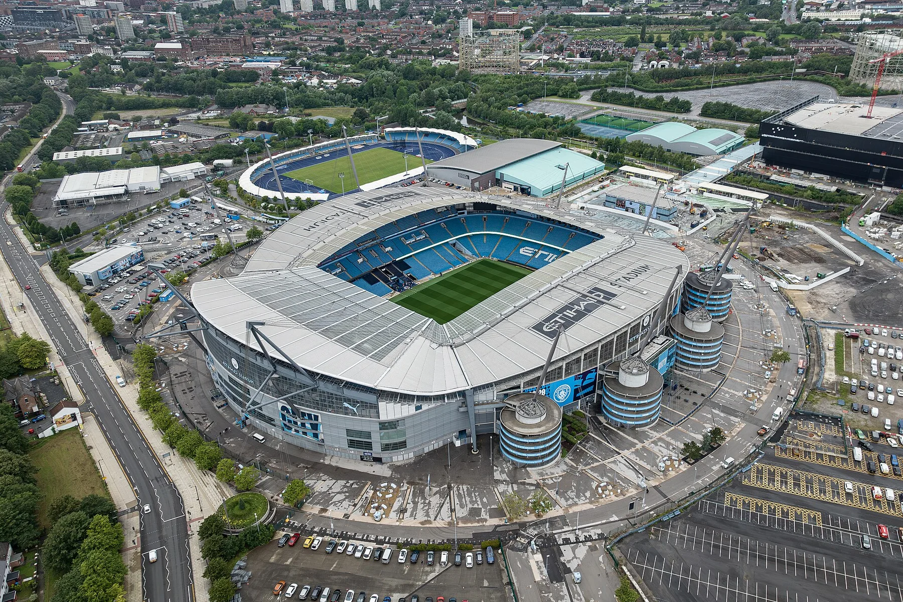 Aerial view of the Etihad Stadium in Manchester with its blue seats, pitch and surrounding car parks