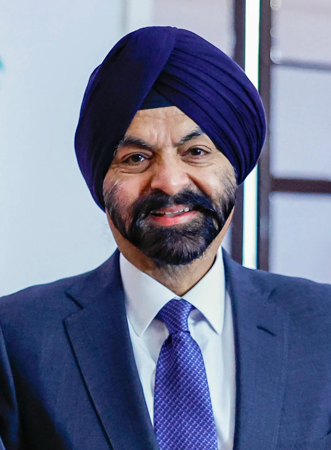 World Bank president Ajay Banga in a navy turban, suit and blue tie, smiling